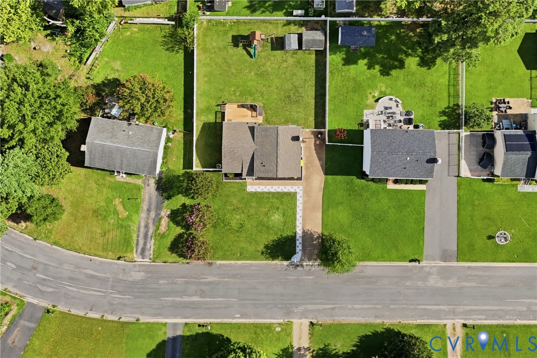 Property featuring an expansive green lawn, asphalt driveway, and mature trees