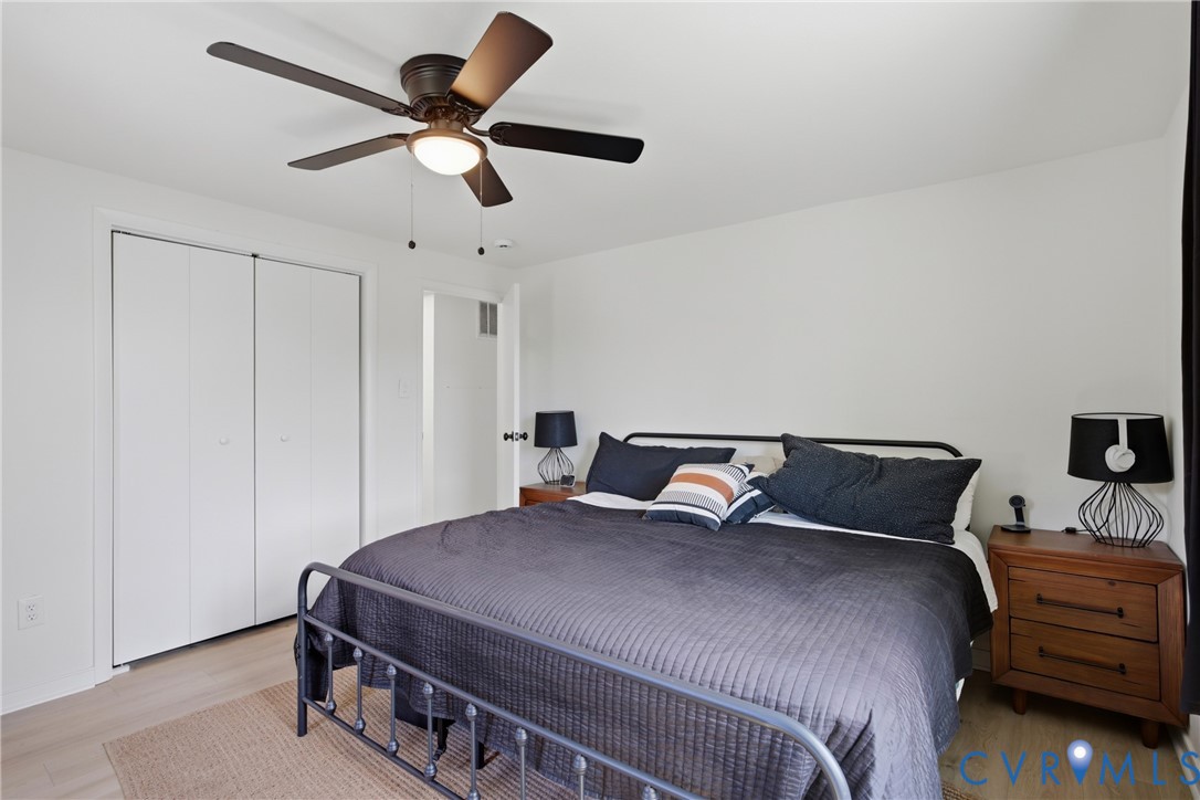 Wood-finish flooring, white walls, and a ceiling fan with integrated lighting