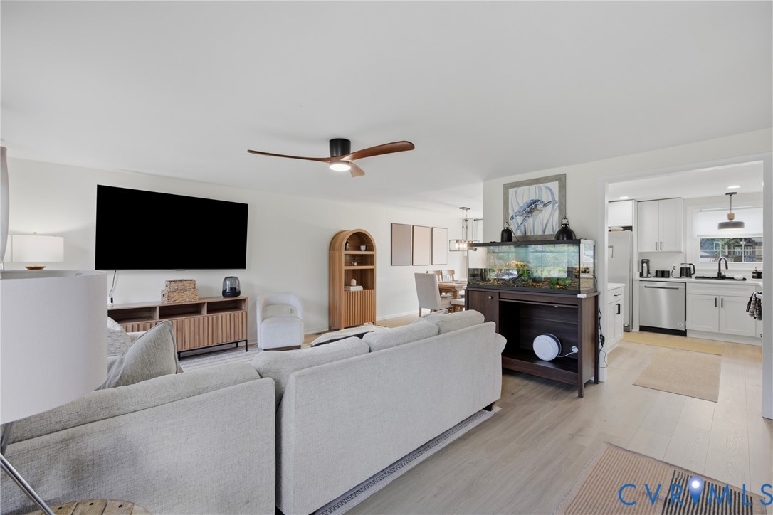 Open-concept living area with wood-finish flooring, a contemporary ceiling fan, and recessed lighting