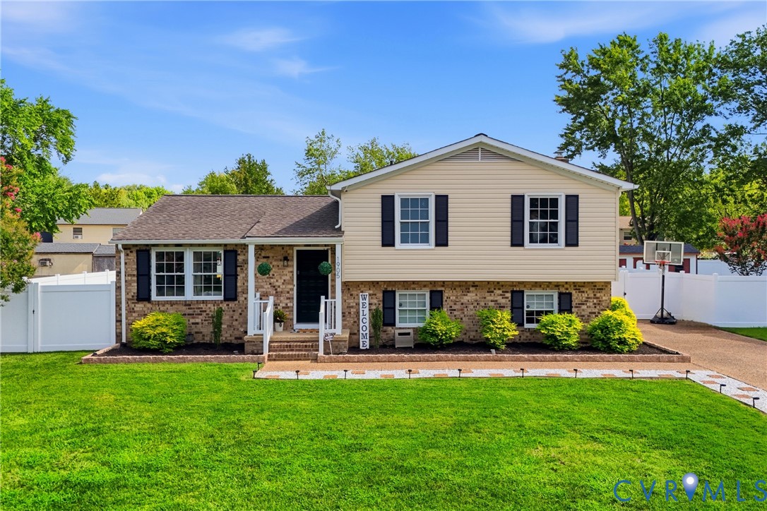 Brick and siding exterior with dark shutters, white front porch railing, and a defined front walkway