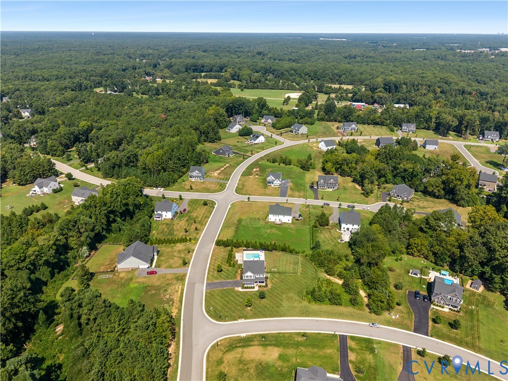 Expansive residential area featuring established homes, paved roads, and significant surrounding tree coverage