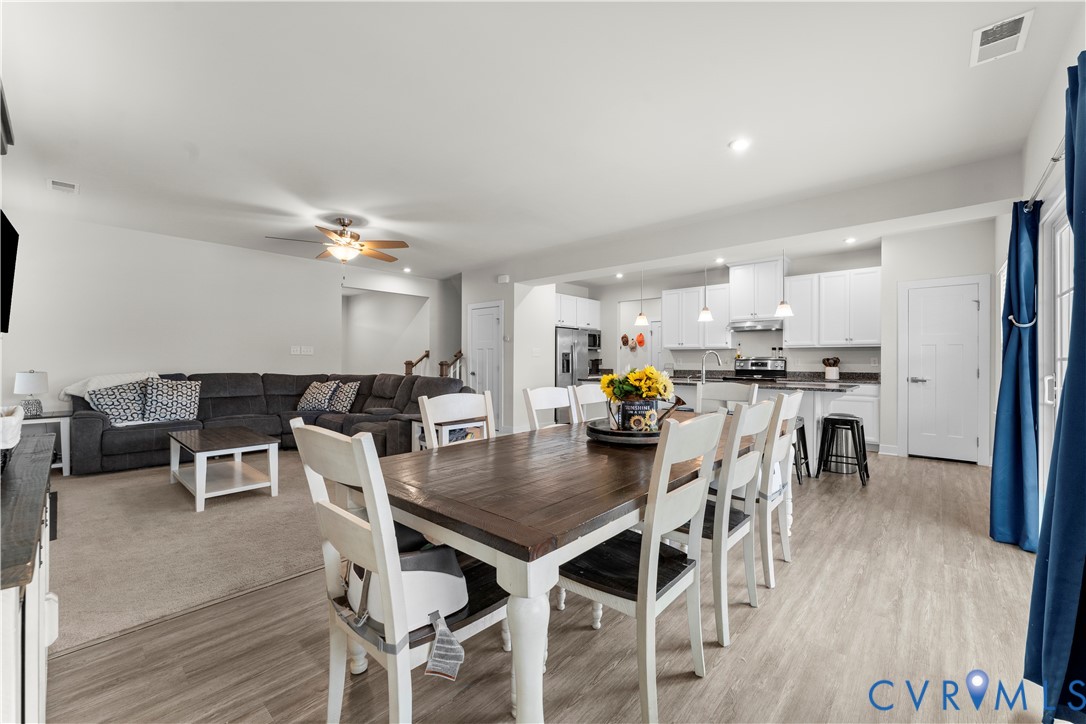 Open-concept living space featuring wood-finish flooring, recessed lighting, and a ceiling fan