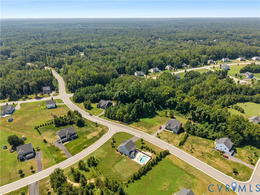 Expansive residential development featuring paved roads and a surrounding wooded landscape