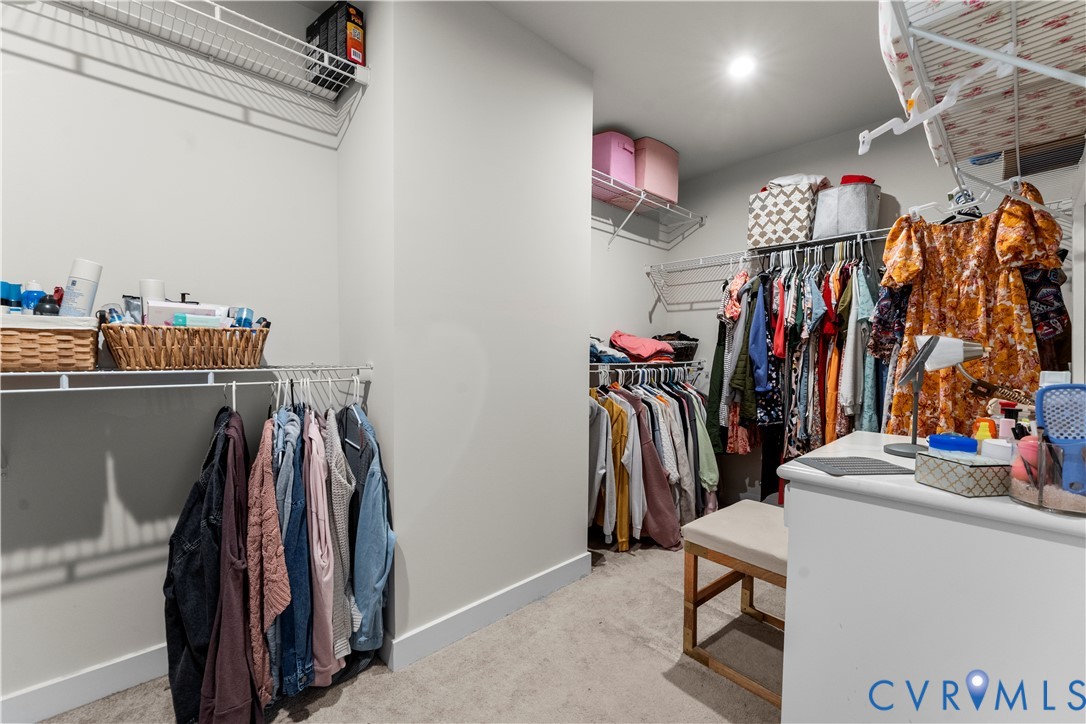 Walk-in closet featuring built-in wire shelving, hanging rods, and recessed lighting