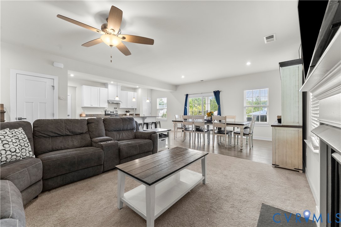 Open-concept living area featuring a ceiling fan, recessed lighting, and an integrated dining space with wood-finish flooring