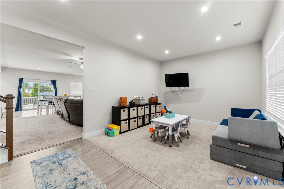 Recessed lighting illuminating a carpeted room with light-colored walls and a window with horizontal blinds