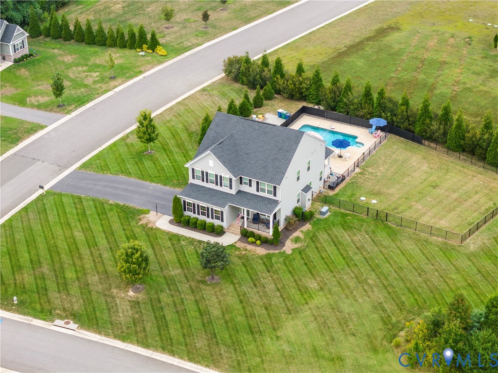 Two-story residence with a gabled roof, a private swimming pool with concrete surround, and a fenced perimeter