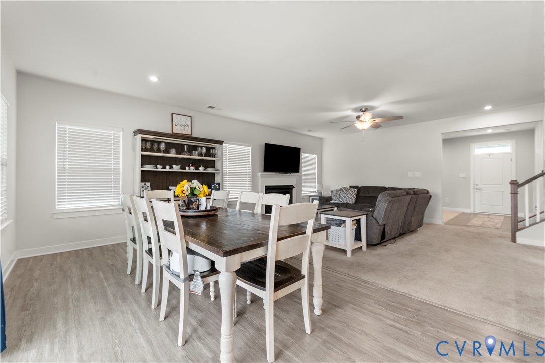 Open-concept living area with wood-finish flooring, recessed lighting, and a built-in shelving unit