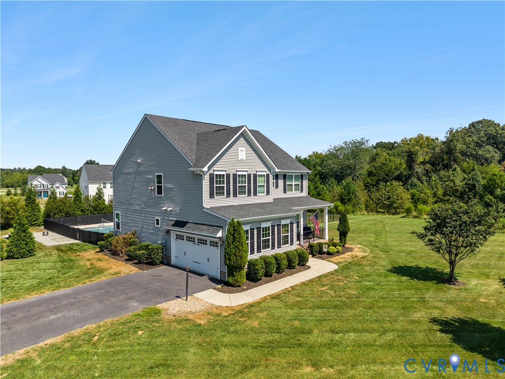 Two-story residence featuring a gray exterior, a covered front porch, and a two-car garage