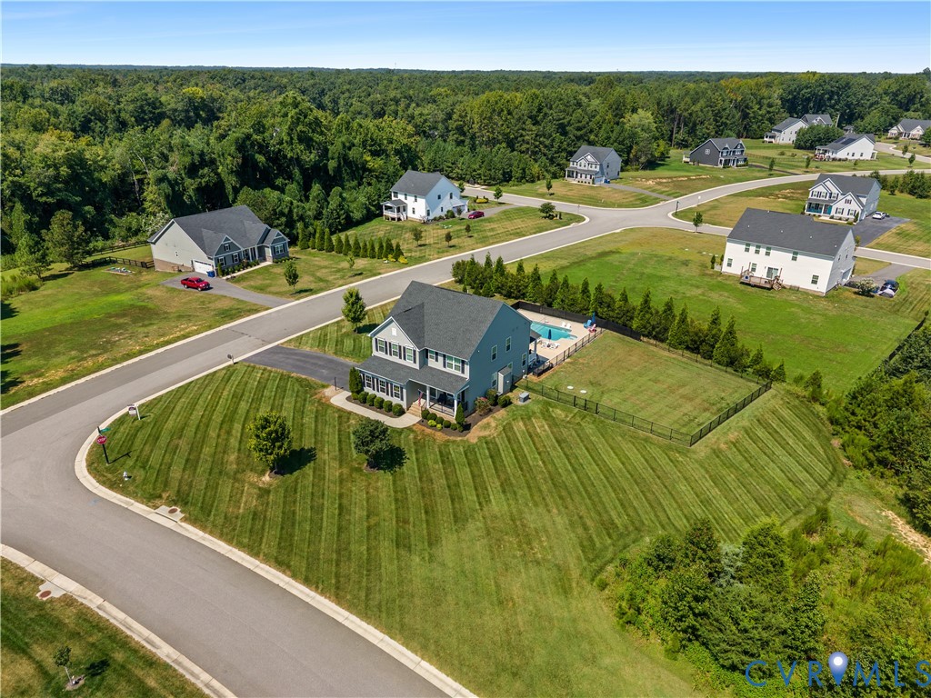 Two-story residence with a covered front porch, fenced rear yard, and an in-ground swimming pool