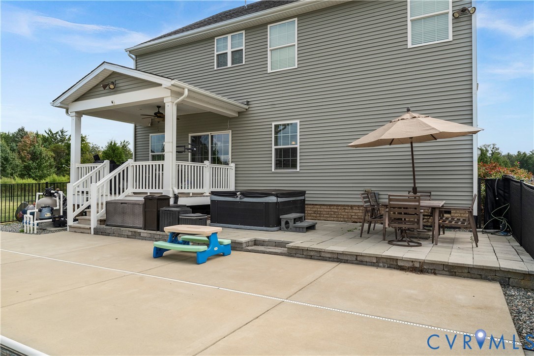 Spacious concrete patio with an elevated stone paver patio
