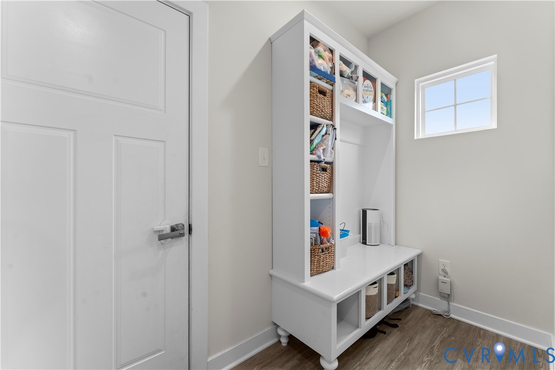 Built-in white storage unit with shelving, bench seating, and cubbies