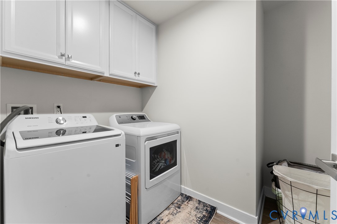White shaker-style cabinetry with chrome hardware, open wood shelving, wood-finish flooring, and light-toned wall paint