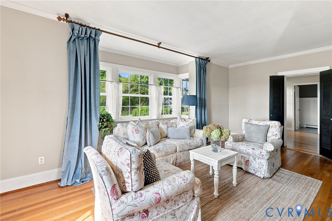 Hardwood flooring, crown molding, multiple windows, and louvered double doors Hardwood flooring, crown molding, multiple windows, and louvered double doors