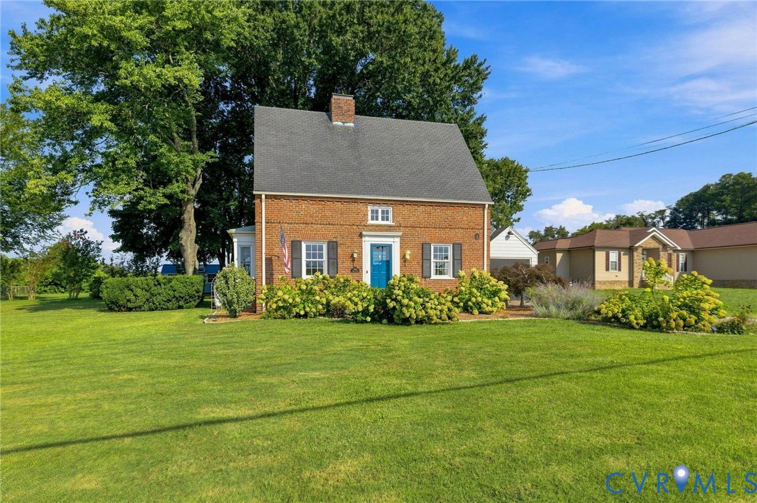 Brick exterior with a gabled roof and a vibrant blue entry door Brick exterior with a gabled roof and a vibrant blue entry door