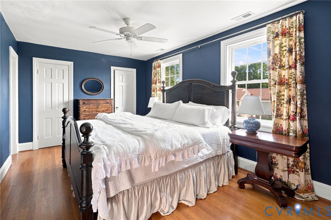 Hardwood flooring, painted walls, two paneled doors, and a ceiling fan