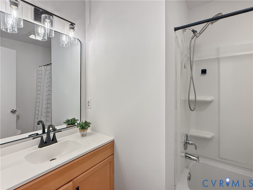 Integrated vanity with a single basin sink, matte black faucet, and wood-finish cabinetry