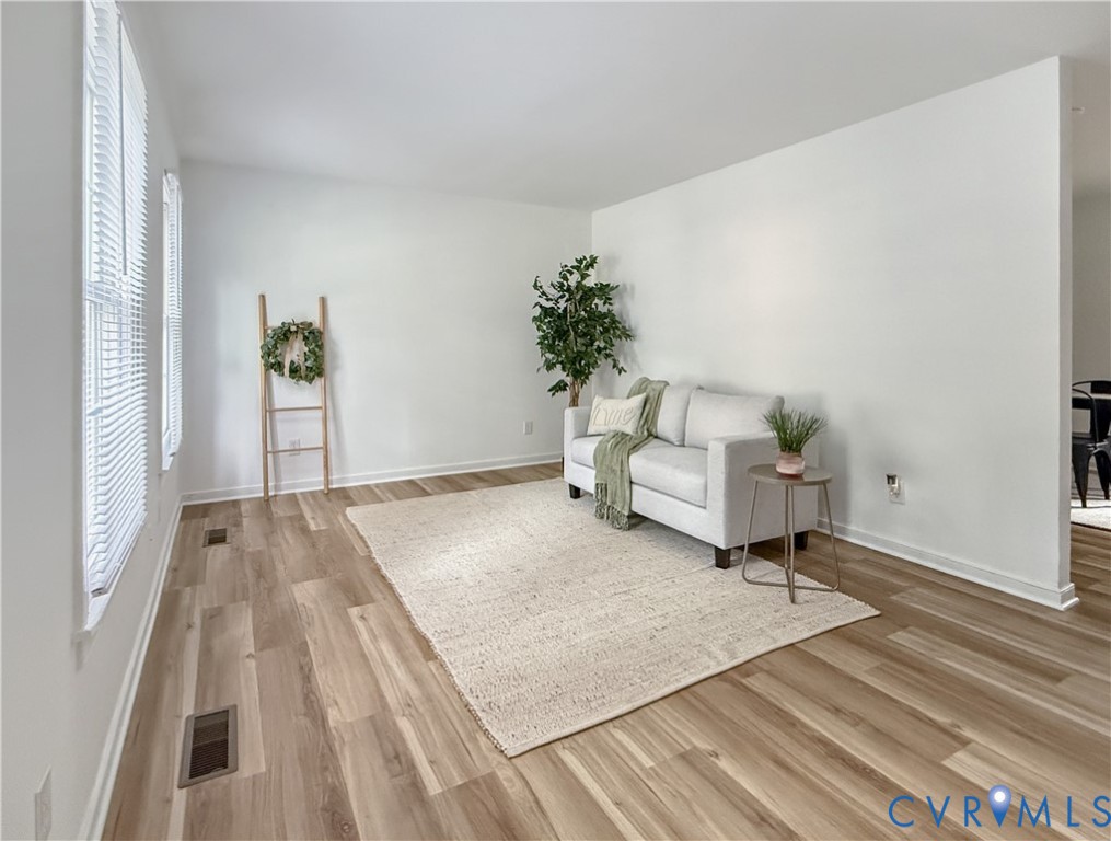 Light wood-finish flooring, white painted walls, and multiple windows with blinds Light wood-finish flooring, white painted walls, and multiple windows with blinds