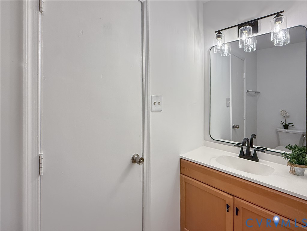 Wood-finish vanity with a white countertop and undermount sink