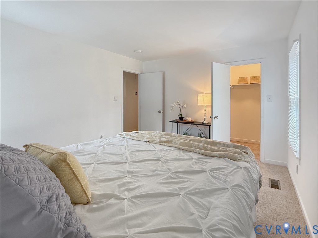 Neutral wall color, window with blinds, carpeted flooring, built-in closet with shelving