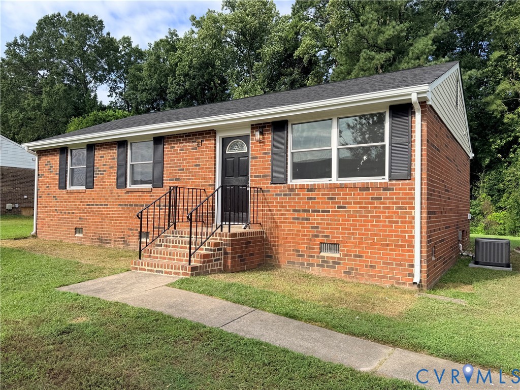 Brick exterior with a dark shingle roof and white gutters