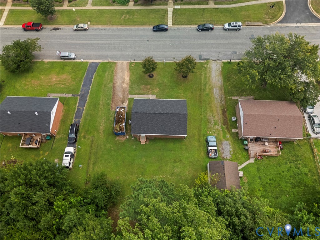 Aerial perspective of a property featuring a central structure with a dark shingle roof