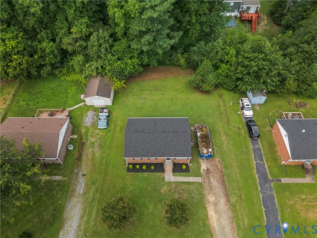 Brick residence with a dark shingle roof and surrounding green lawn