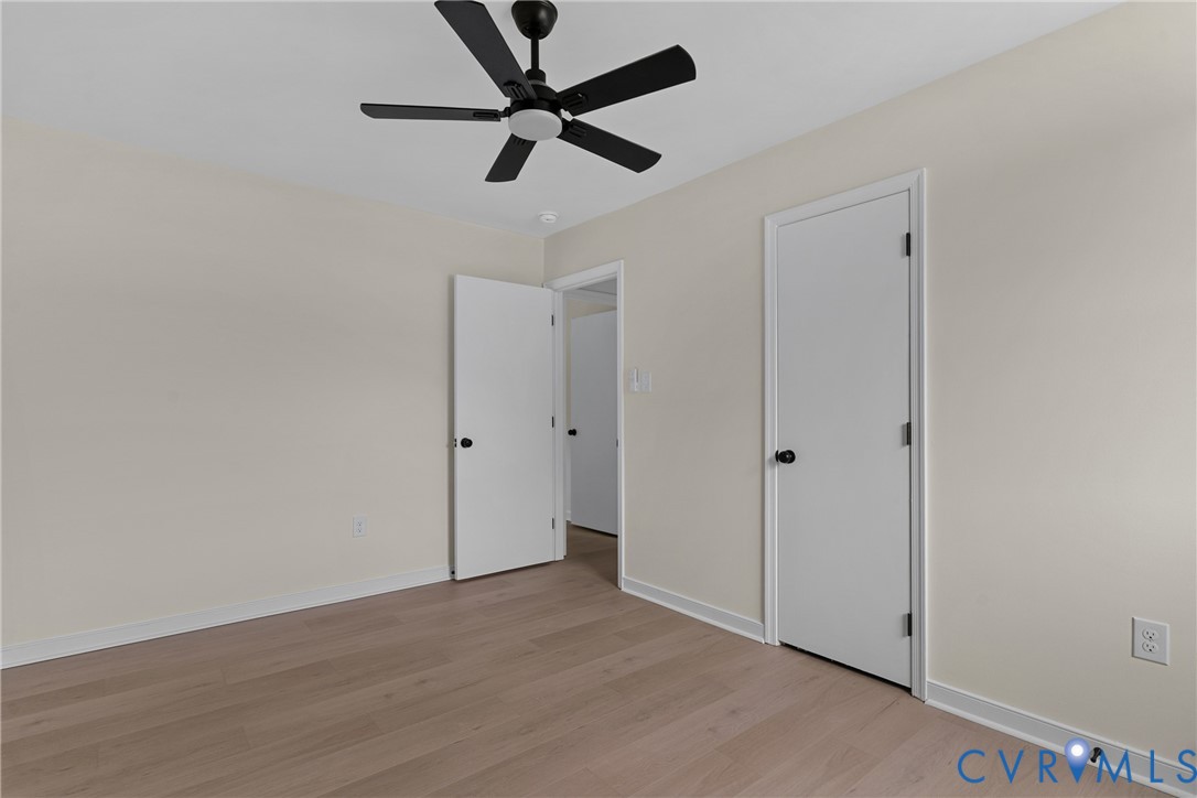 Room featuring light wood-finish flooring, light neutral-toned walls, and white trim