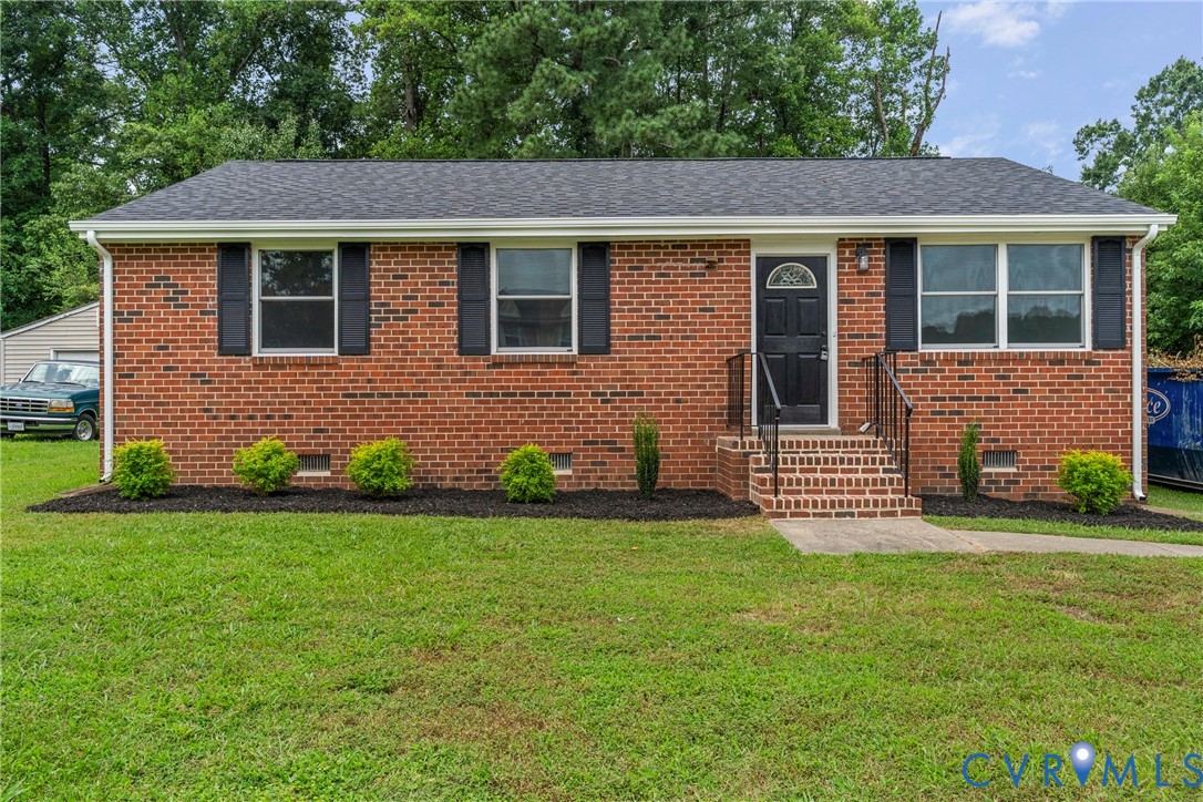 Brick ranch-style facade with a dark shingle roof and white gutters