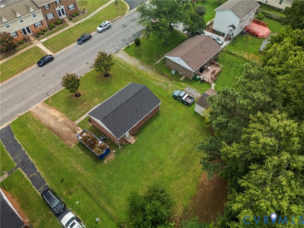 Brick-clad property with a dark shingle roof situated on a green lawn