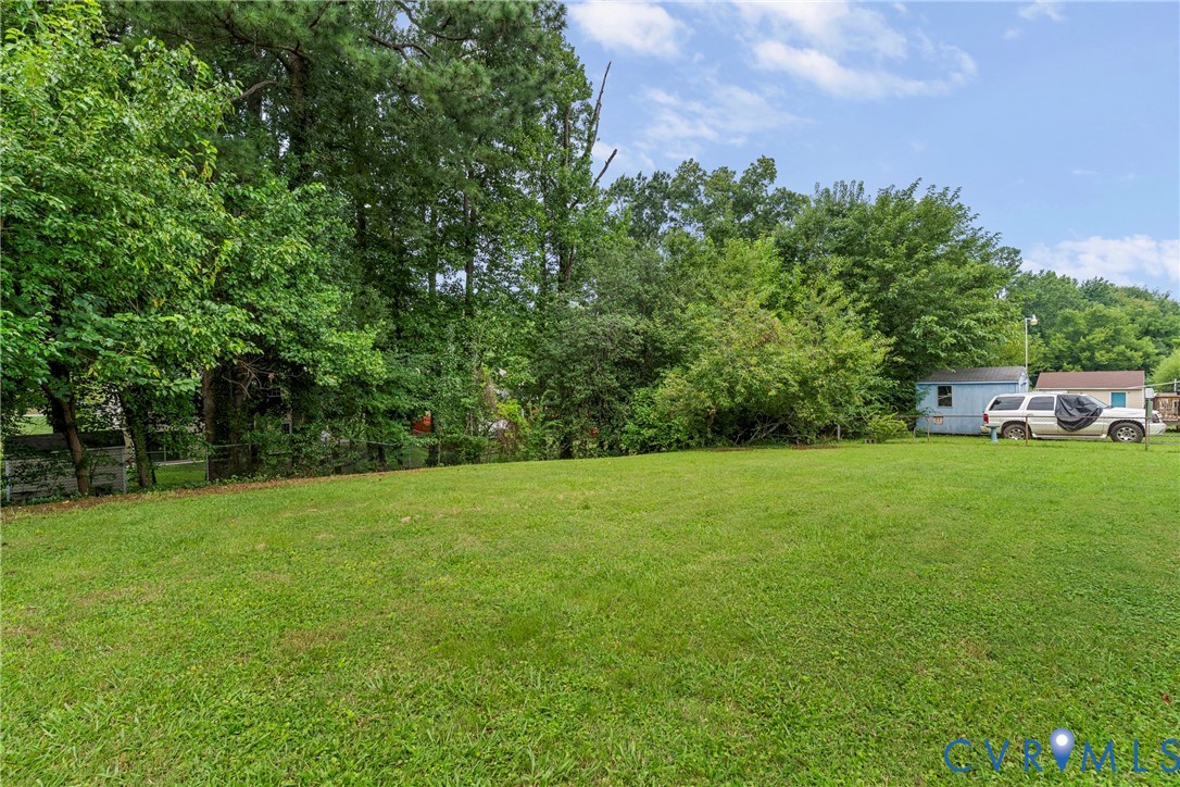 Expansive grassy area with mature trees framing the perimeter