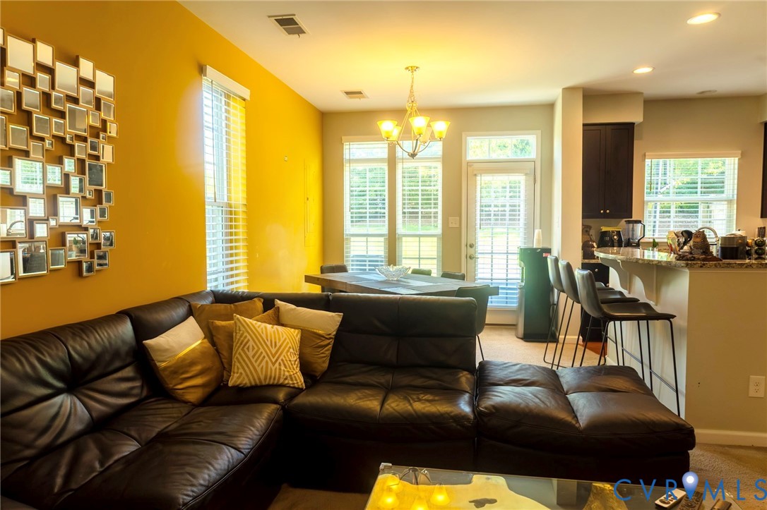 Open-concept living area with a dining space, kitchen, and ample natural light from multiple windows