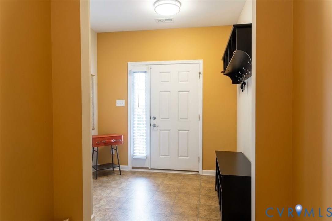 Entryway with tile flooring, a white paneled door featuring a full-length sidelight, and a flush mount ceiling light