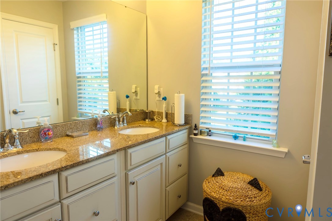 Dual undermount sinks set into a spacious vanity with a stone-finish countertop