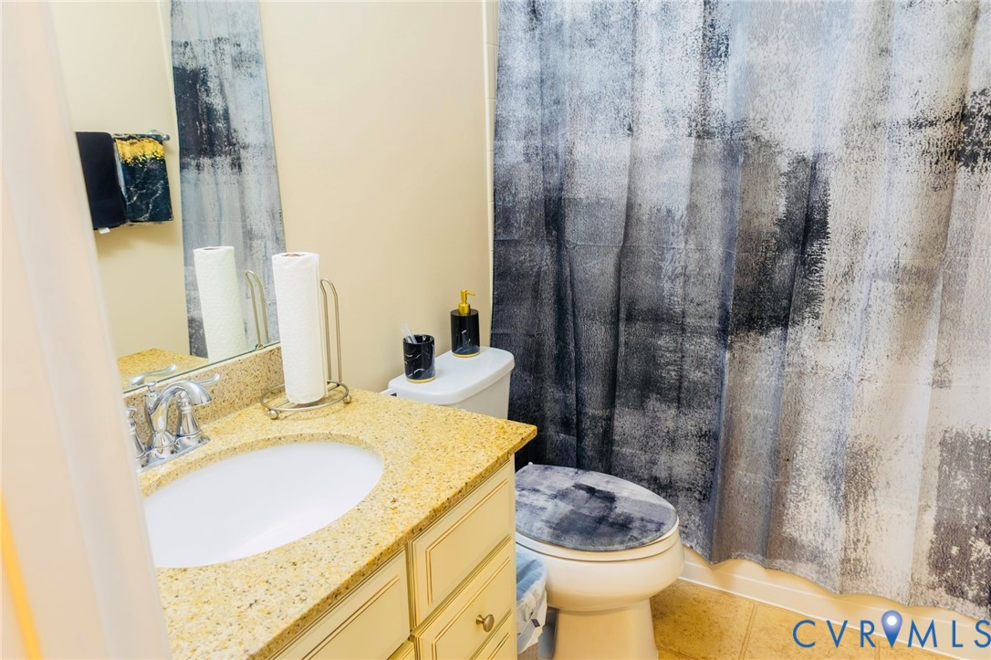 Bathroom vanity with a granite-style countertop, undermount sink, and chrome faucet