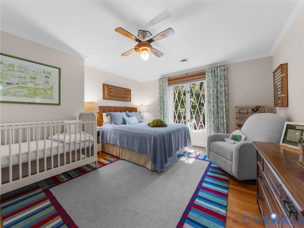 Hardwood flooring, crown molding, ceiling fan, natural light, and window treatments