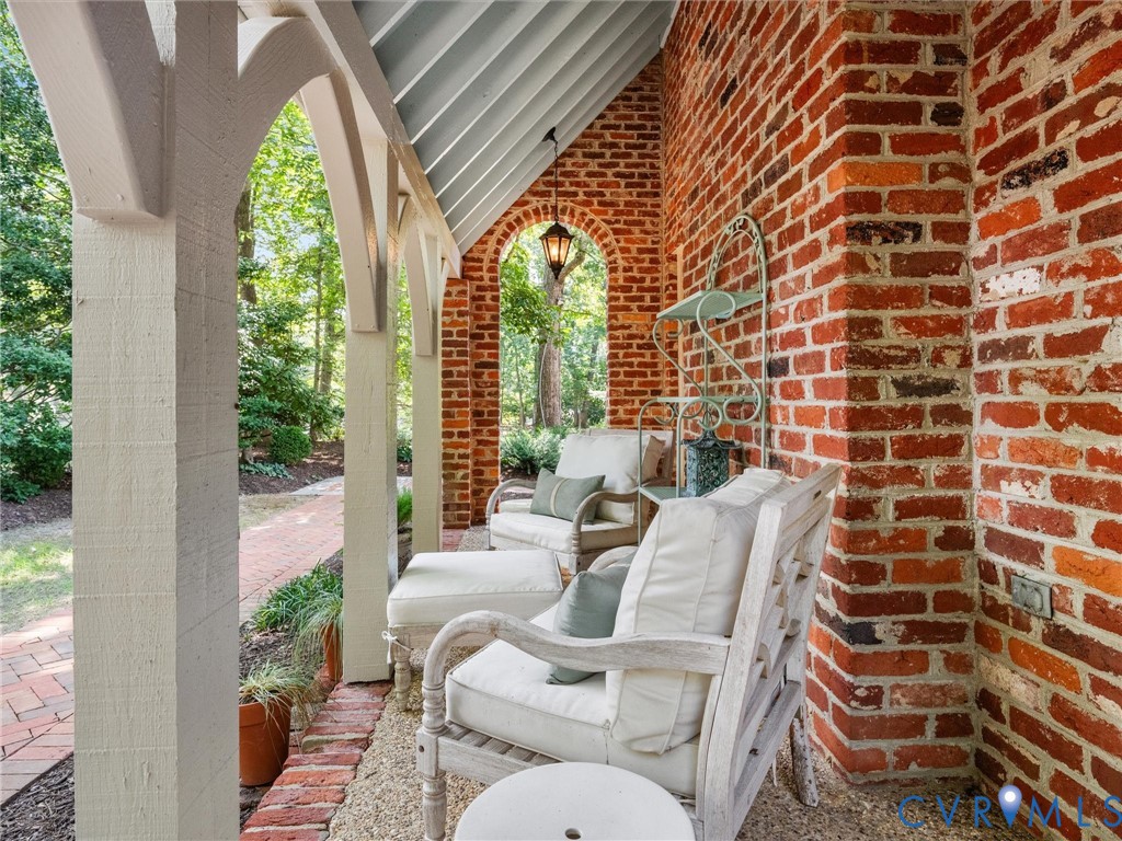 Brick exterior wall with an arched opening and a hanging lantern fixture