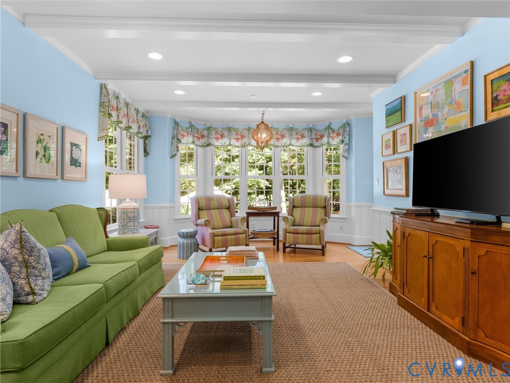 Recessed lighting, exposed beam ceiling, bay window, wainscoting, and wood-finish flooring