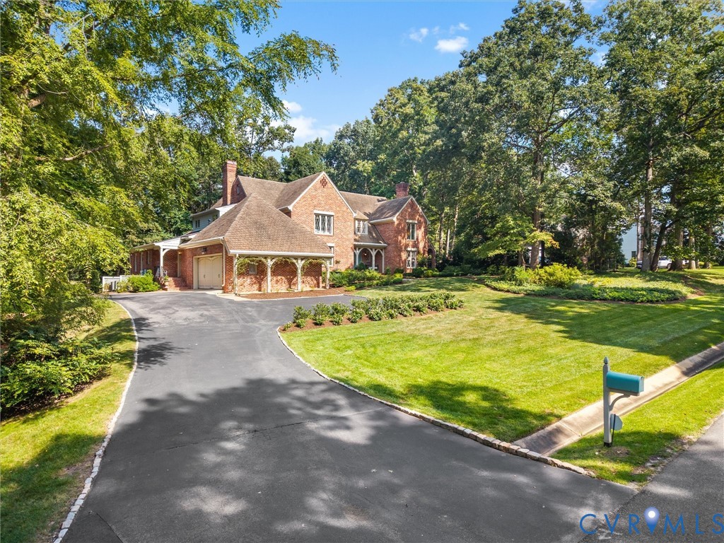 Brick exterior with a shingle roof and multiple gables Brick exterior with a shingle roof and multiple gables