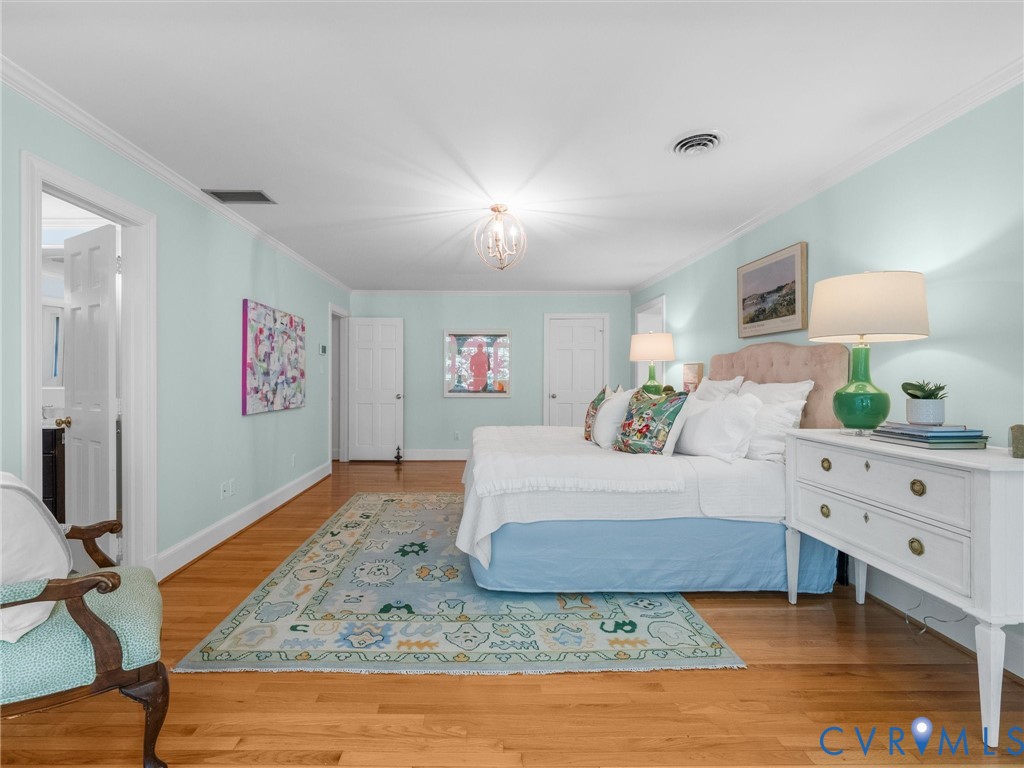 Hardwood flooring, crown molding, white trim, recessed lighting, and a chandelier fixture