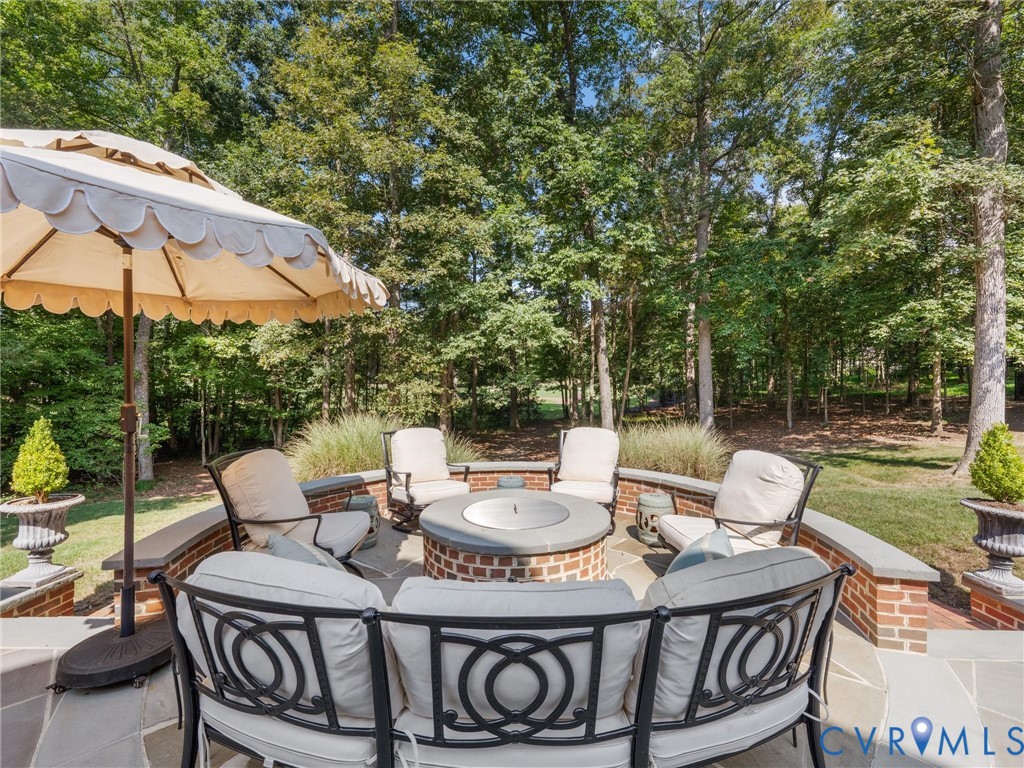 Stone patio with a built-in brick fire pit and surrounding brick wall