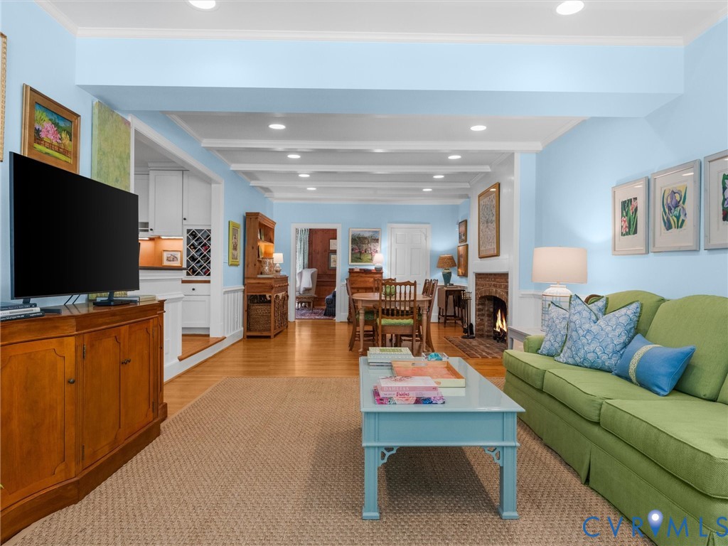 Recessed lighting, wood-finish flooring, exposed ceiling beams, brick fireplace, and built-in wine storage