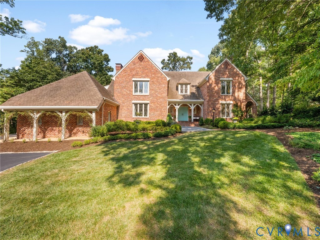 Brick exterior with an arched entry, prominent gables, and a columned porte-cochre Brick exterior with an arched entry, prominent gables, and a columned porte-cochre