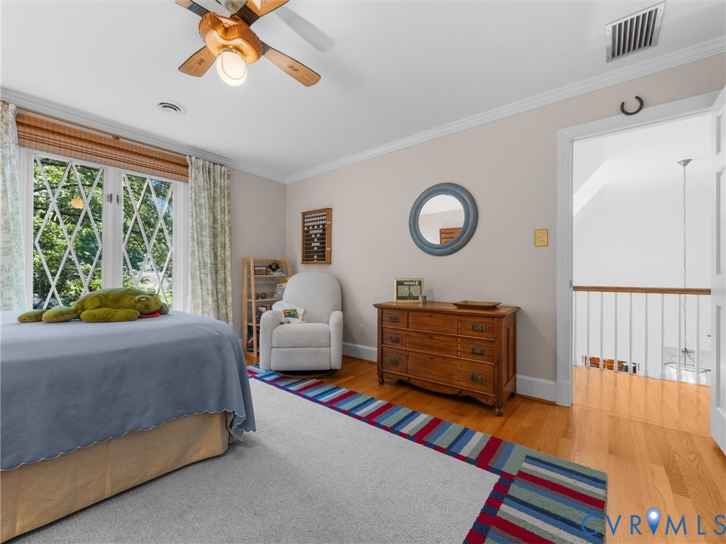 Hardwood flooring, diamond-pane windows, crown molding, and a ceiling fan