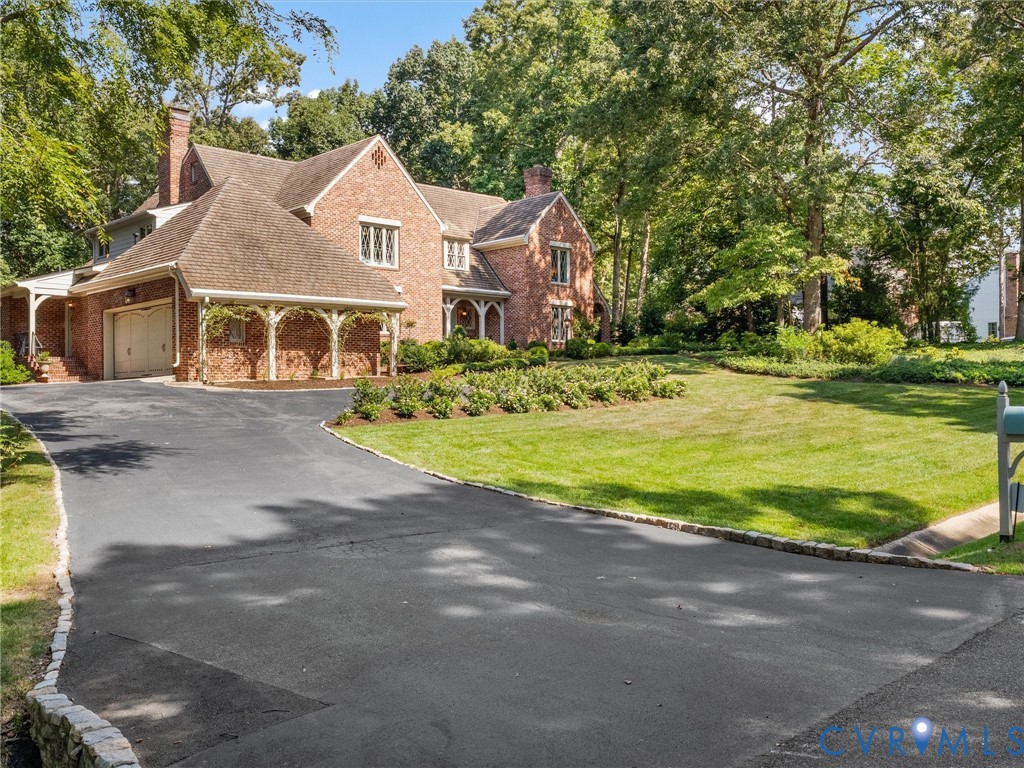 Brick exterior with a large asphalt driveway and stone curbing Brick exterior with a large asphalt driveway and stone curbing