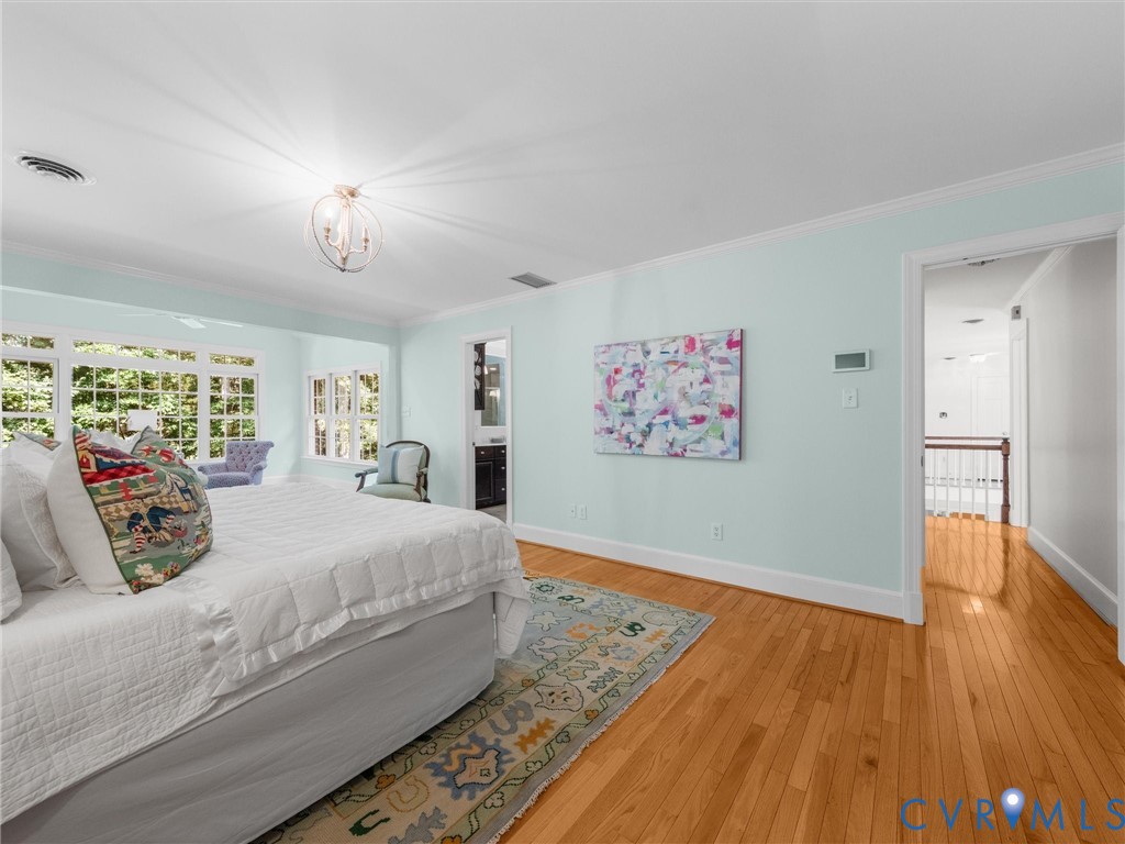 Hardwood flooring, multi-pane windows, a decorative ceiling light fixture, and a built-in vanity with a dark cabinet