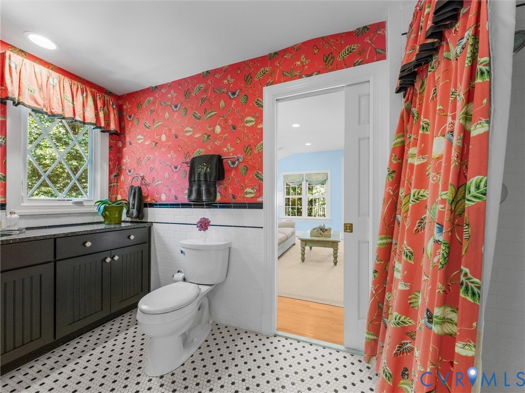 Hexagonal tile flooring, black cabinetry with stone countertops, and a window with diamond-patterned muntins