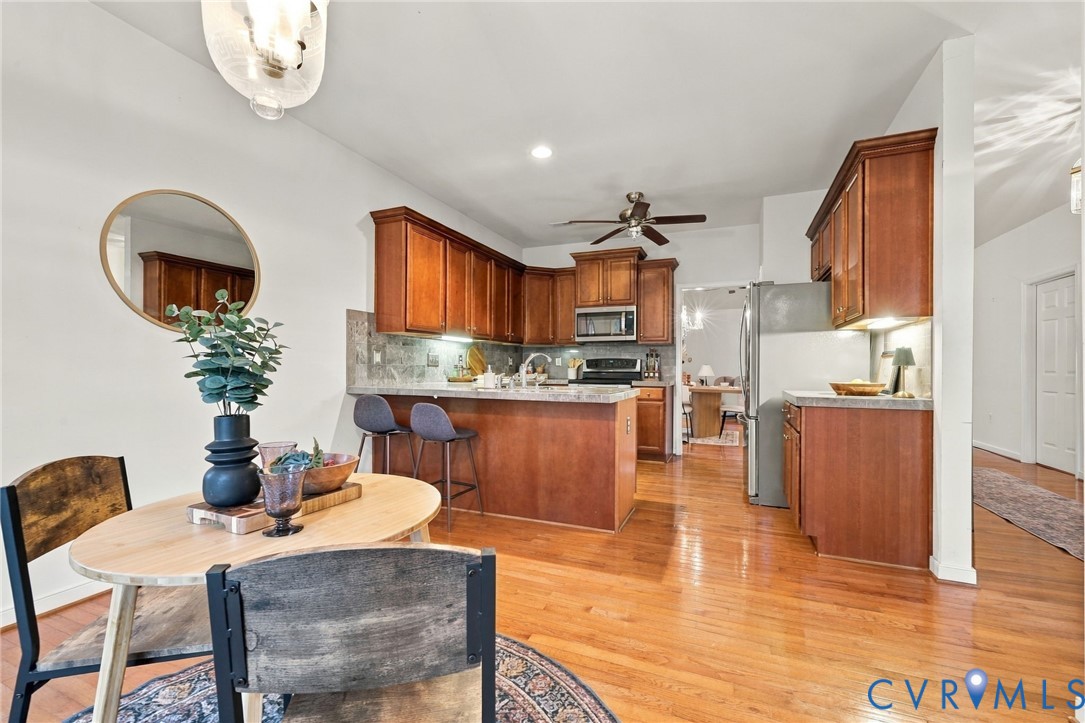 Hardwood flooring, wood cabinetry, stainless steel appliances, recessed lighting, and a ceiling fan