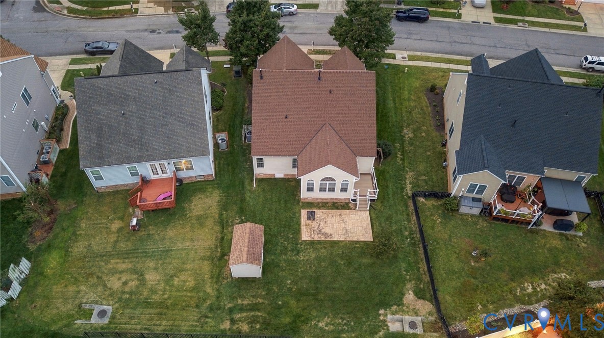 Rear exterior with a multi-level deck, concrete patio, and detached storage shed