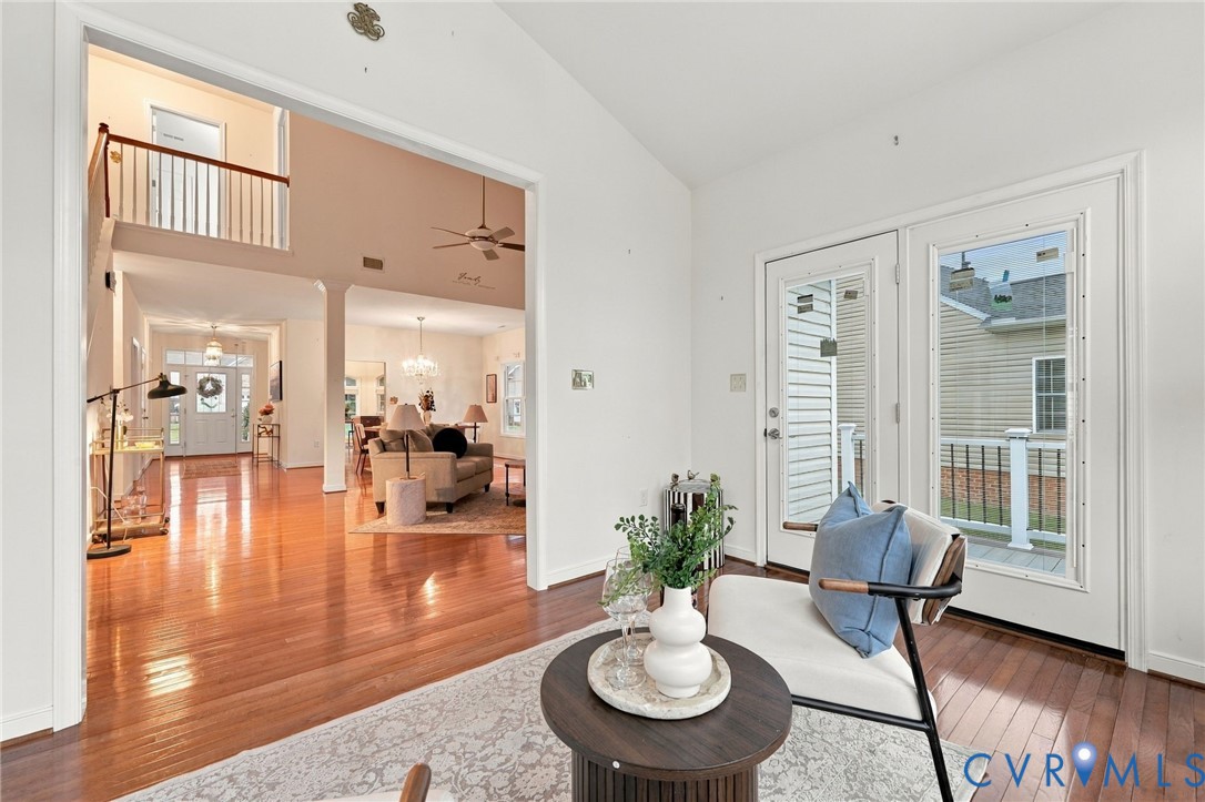 Expansive interior with hardwood flooring, a two-story ceiling, and a second-level open railing